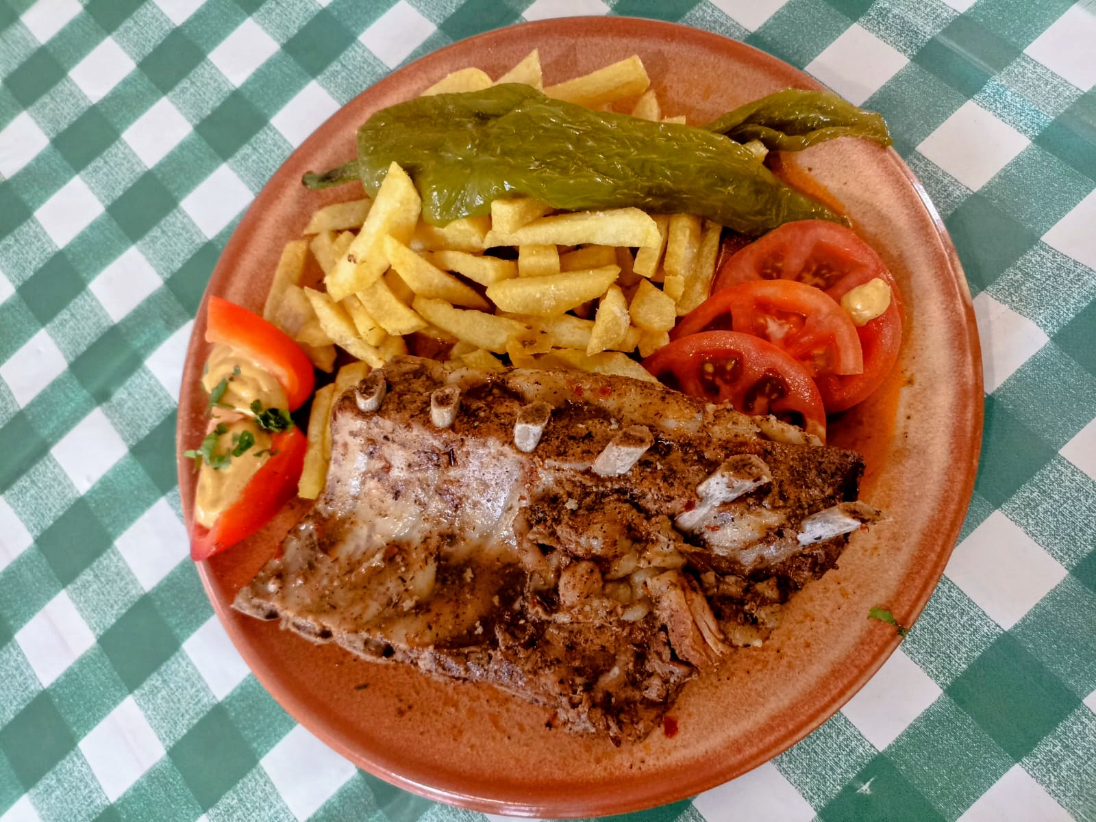 Costillar de cerdo en salsa al horno con patatas, tomate y pimiento